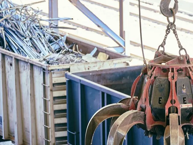 Hulladékválogató és -feldolgozó szakember ellenőrzi a válogatószalagon haladó anyagot